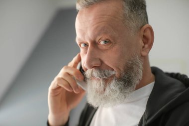 İşyeri ofis cep telefonunda konuşan üst düzey adam