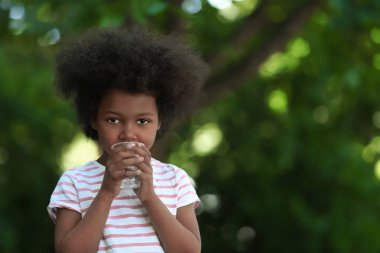 Afro-Amerikan çocuk içme suyu açık havada. Su kıtlığı kavramı