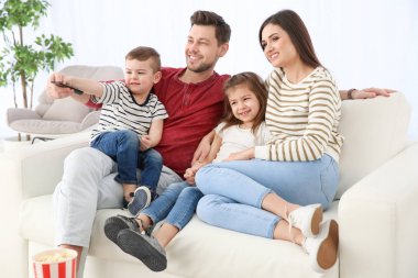 Evde kanepede televizyon izlerken aile
