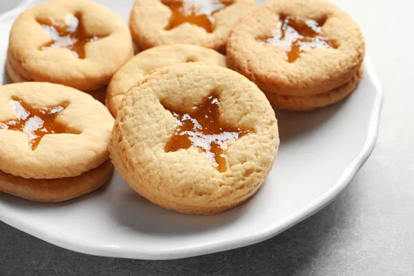 Tasty Linzer cookies with jam on plate