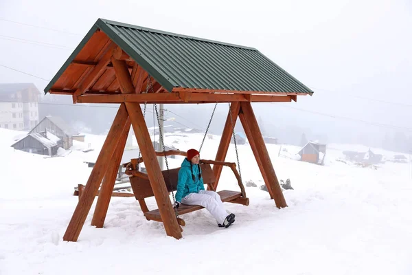 Hermosa Mujer Sentada Banco Oscilante Complejo Nevado Vacaciones Invierno —  Fotos de Stock
