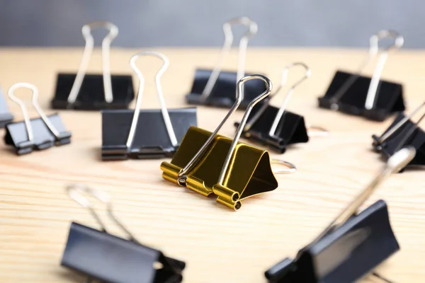 One Golden Binder Clip Black Ones Wooden Table Difference Uniqueness — Stock Photo, Image