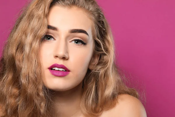 Renkli arka planda güzel kaşları olan genç bir kadın, yakın plan.