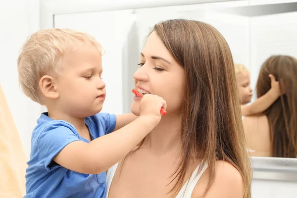 かわいらしい子供の浴室で彼の母親の歯のクリーニング — ストック写真