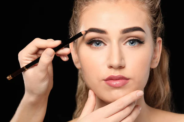 Junge Frau Unterzieht Sich Augenbrauenkorrektur Vor Dunklem Hintergrund — Stockfoto