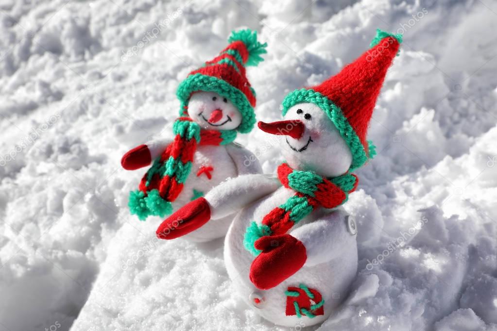 Two toy snowmen on sunny frosty day. Winter vacation
