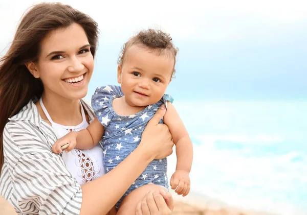 Mor med lilla dotter på stranden — Stockfoto