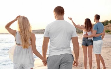 Genç bir çift sahilde yürüyor.