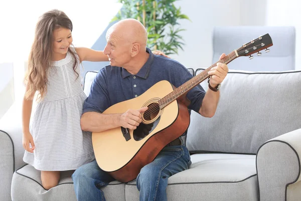 Hombre mayor con nieta tocando la guitarra — Foto de Stock