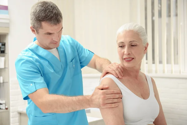Bejaarde Vrouw Krijgen Schouder Massage Bij Fysiotherapie Kantoor — Stockfoto