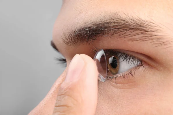 Человек кладет контактные линзы в глаз — стоковое фото