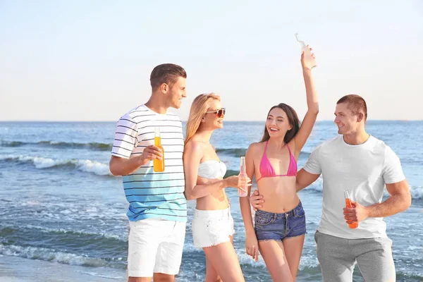 Jonge mensen met drank op strand — Stockfoto