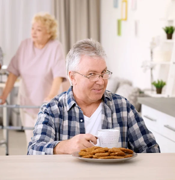 パーソナルケア ホームで朝食を持っている年配の男性 — ストック写真