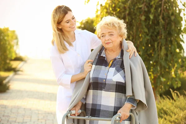 Senior Vrouw Met Wandelaars Verpleegster Uit Verzorgingsinstelling Park — Stockfoto