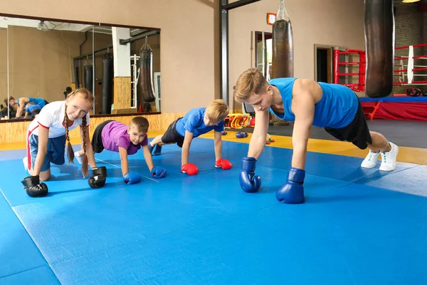 Küçük Çocuklar Spor Salonunda Antrenör Ile Yapıyor — Stok fotoğraf