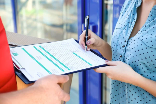 Frau unterschreibt für Paketzustellung — Stockfoto