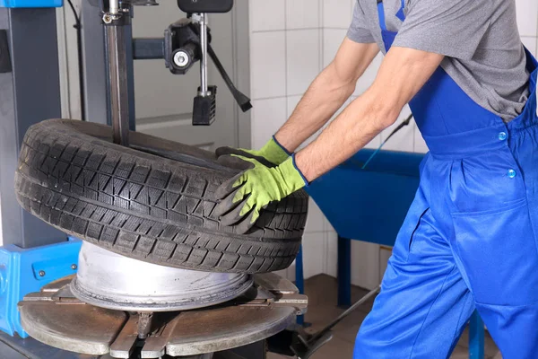汽车维修中心采用现代设备更换轮胎的专业技工 — 图库照片