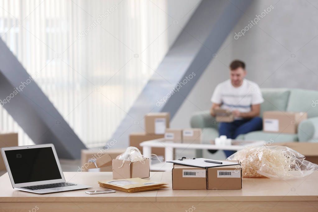 Parcel boxes and envelopes ready for shipment to client on table at home