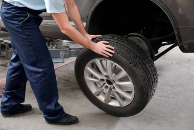 Mekanik değişen araba tekerleği garajda. Lastik Servisi