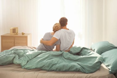 genç bir çift yatakta oturmuş 