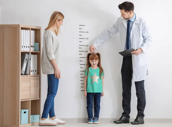 Doctor measuring height of girl — Stock Photo, Image