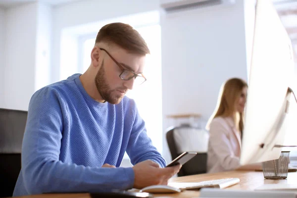 Jeune homme travaillant dans le bureau — Photo