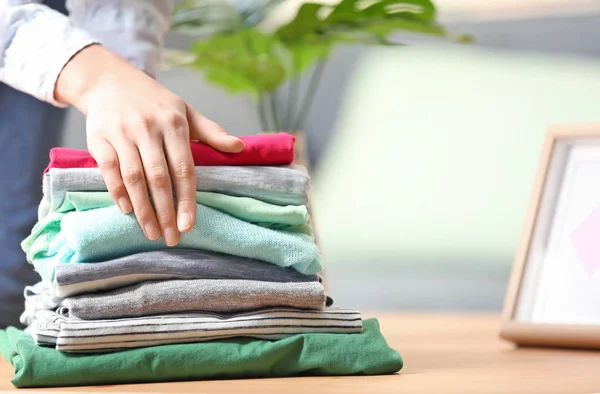 Woman putting stack of clothes — Stock Photo, Image