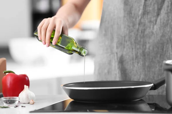 Woman pouring cooking oil — Stock Photo, Image