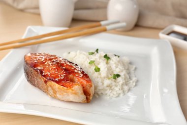 Plaka üzerinde pirinç ile balık biftek servis