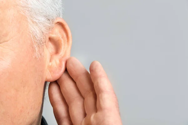Dojrzały Człowiek Problem Słuchu Szarym Tle Zbliżenie — Zdjęcie stockowe