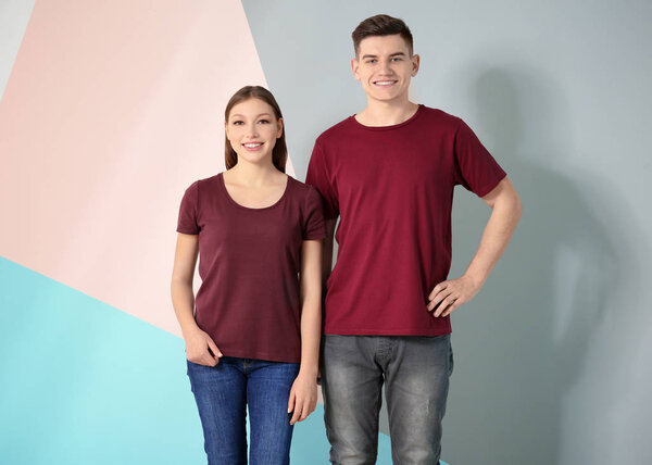 Молодой человек и женщина в стильных футболках на цветном фоне. Макет для дизайна
