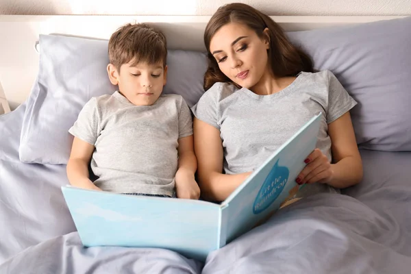 Mother reading bedtime story to son at home