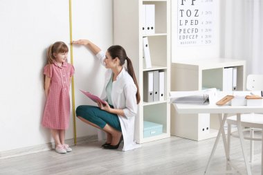 Küçük kız doktorun ofisinde boy ölçme