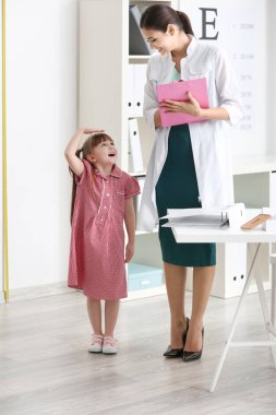 Küçük kız doktorun ofisinde boy ölçme