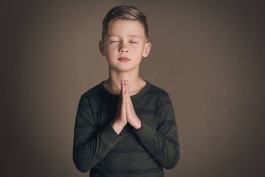 Koyu arka plan üzerinde dua dini küçük çocuk