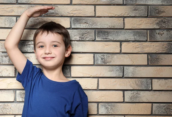 Liten Pojke Mäta Höjd Nära Tegelvägg — Stockfoto