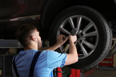 Mekanik değişen araba tekerleği garajda. Lastik Servisi