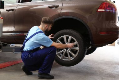 Mekanik değişen araba tekerleği garajda. Lastik Servisi
