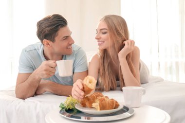 Genç güzel çift yatakta kahvaltı