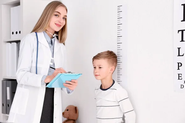 Läkaren mäta höjden på pojke — Stockfoto