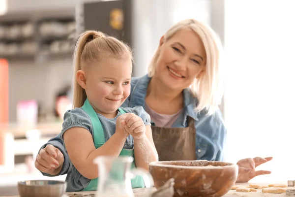 Kleines Mädchen und Großmutter mit Mehl — Stockfoto