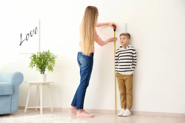 Mulher medindo altura do menino — Fotografia de Stock