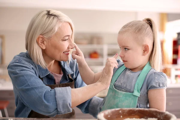 Menina e avó se divertindo na cozinha — Fotografia de Stock