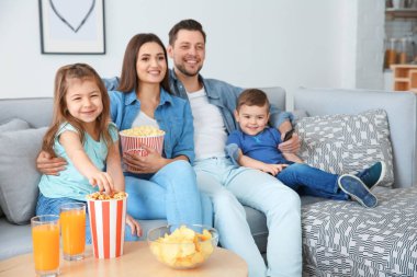 Evde kanepede televizyon izlerken aile