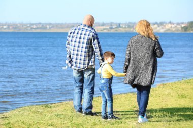 Kilolu çift güneşli günde nehir kenarında yürüyüş oğlu ile