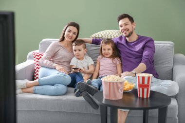 Evde kanepede televizyon izlerken aile