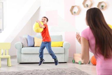 Dadı ve küçük çocuk evde topla oynamayı