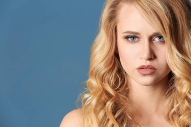 Renk arka plan üzerinde uzun dalgalı saçlı güzel genç kadın