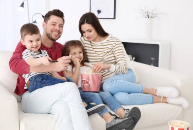 Evde kanepede televizyon izlerken aile