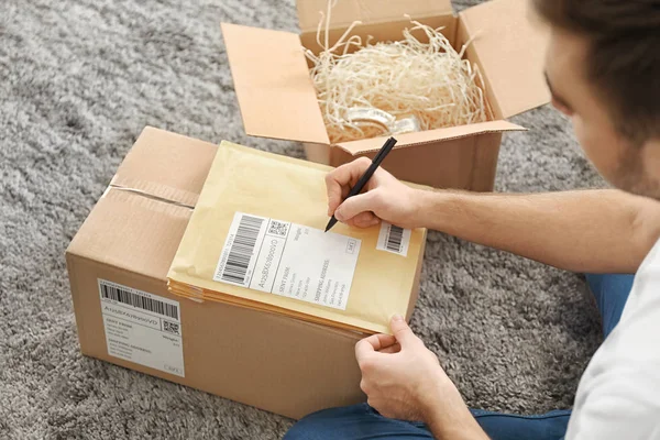 Jovem preparando envelopes de parcelas — Fotografia de Stock